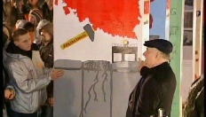 Lech Walesa duwt de (domino)muur omver